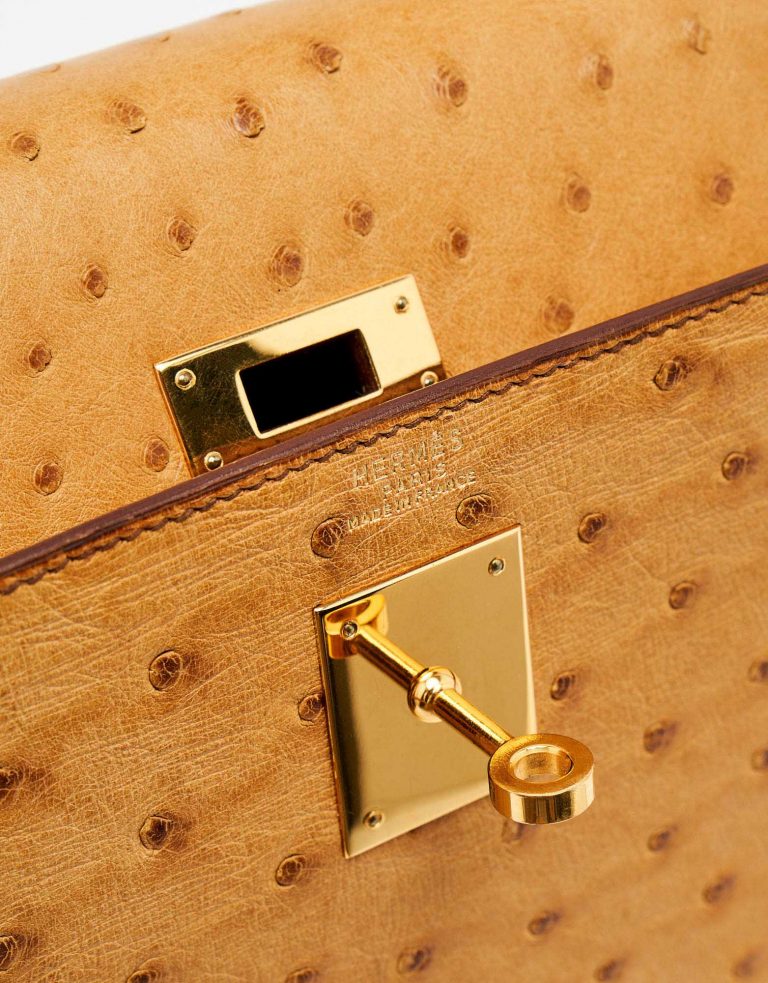 Gold-pleated hardware of a pre-loved Hermès Kelly 32 Ostrich Gold on SACLÀB