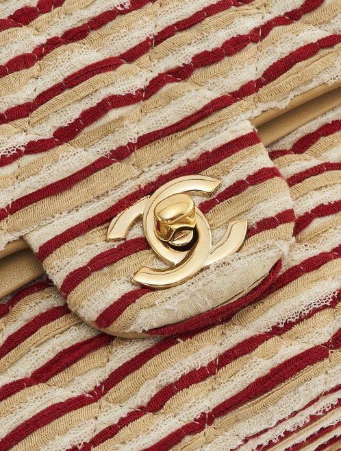 Détail de la quincaillerie en or sur une édition limitée de Chanel Timeless Medium en tissu et perles en rouge et blanc sur SACLÀB