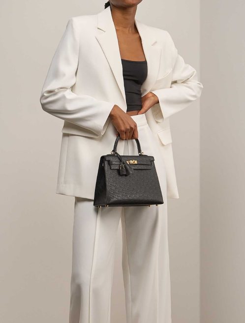 Hermès Kelly 25 Strauß Schwarz auf Modell | Verkaufen Sie Ihre Designer-Tasche