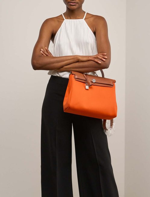 Hermès Herbag 31 Toile / Vache Hunter Orange Minium / Fauve on Model | Verkaufen Sie Ihre Designer-Tasche